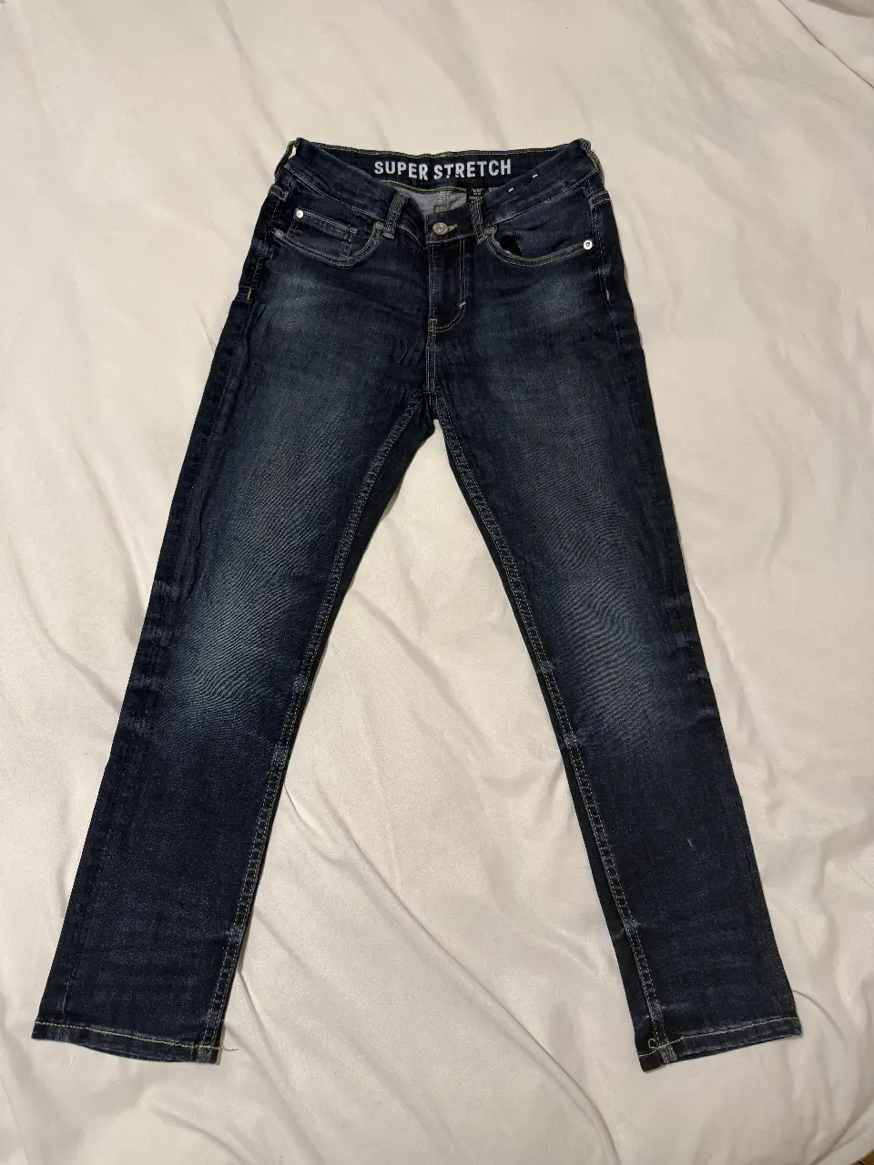 Jeans chupín de niño, color azul oscuro, con detalle "Super Stretch" en la cintura. Talle 140, Skinny Fit & Denim. Ideal para un look casual y moderno. TALLE PARA NIÑOS DE 9 a 10 AÑOS. Medidas aproximadas: entrepierna 60cm, muslo 20cm, ancho de bota 13cm, cintura 32cm y cadera 38cm