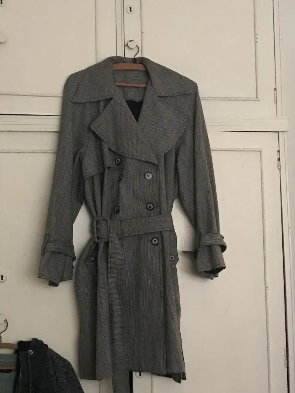 Trench gris con cinturón, ideal para un look elegante y sofisticado. Perfecto para el invierno.