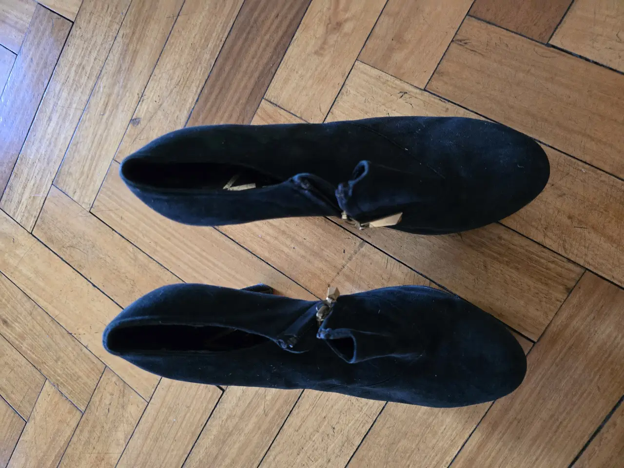 Botines de gamuza negros con taco alto y cierre lateral. Ideales para un look elegante y sofisticado.