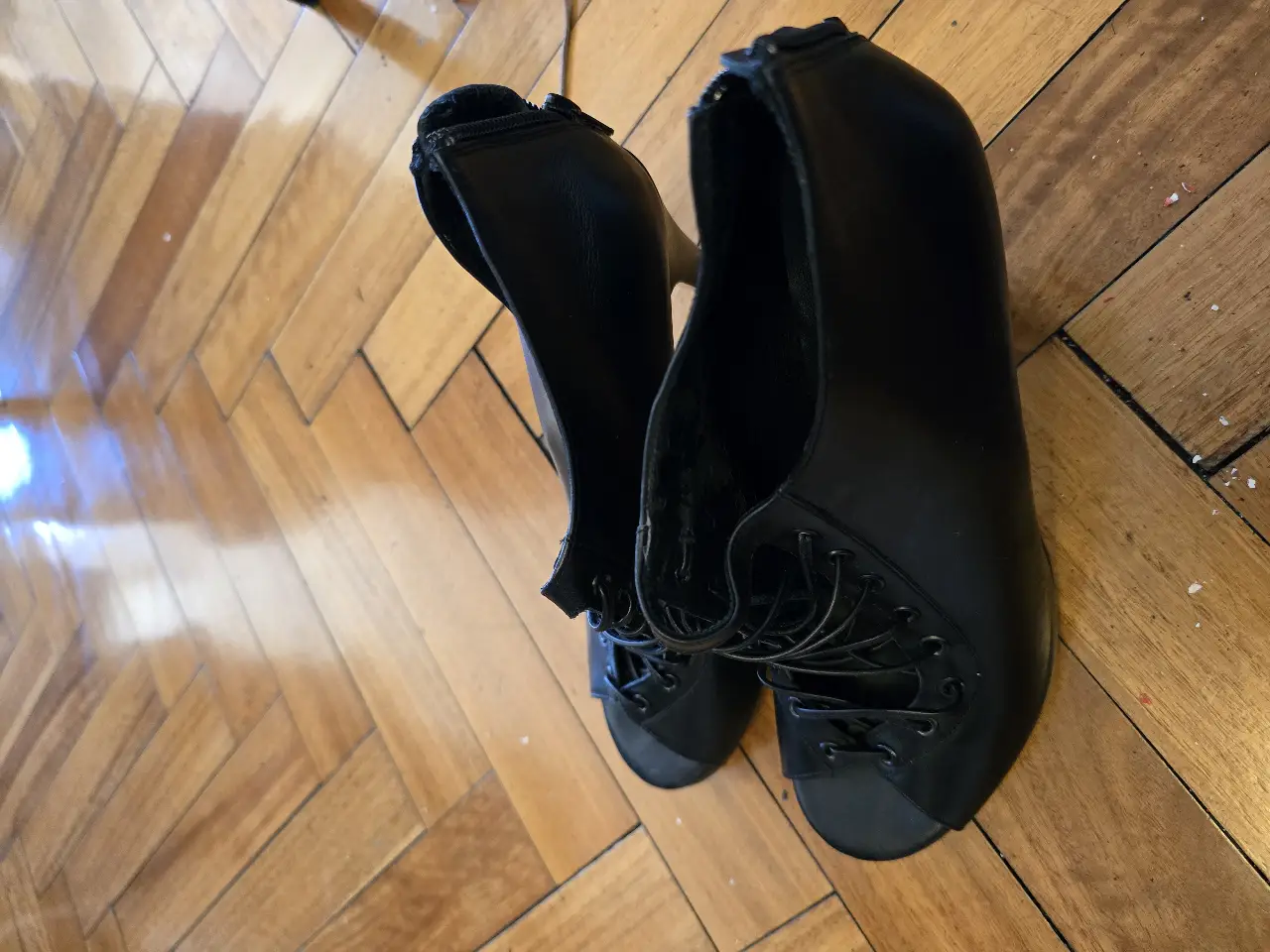 Botines de cuero negro con detalles de cordones y cierre en la parte trasera. Ideales para un look elegante y moderno.