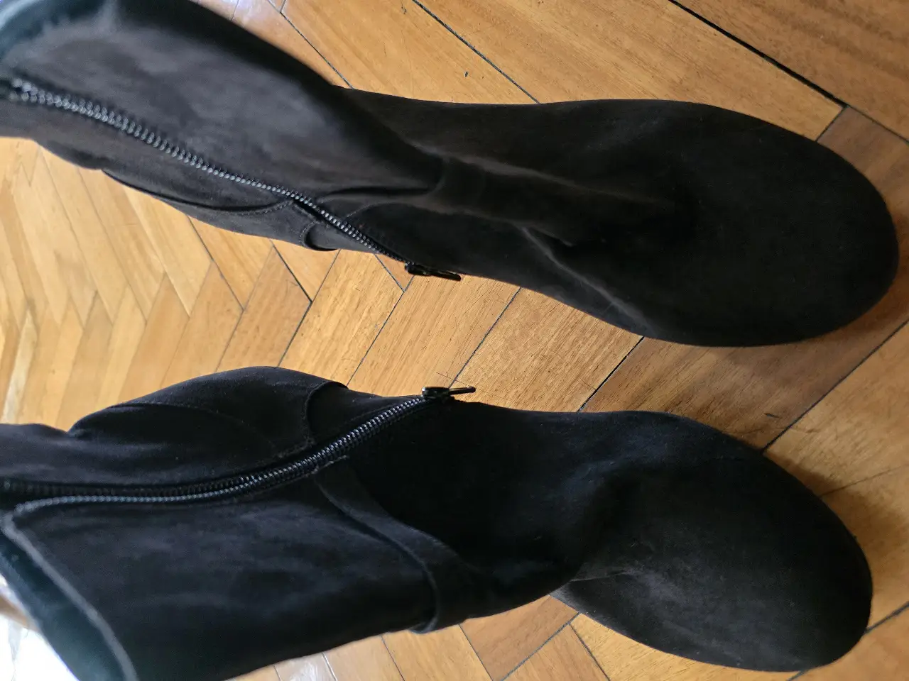 Botines negros de gamuza con taco fino y cierre lateral. Ideales para un look elegante y sofisticado.