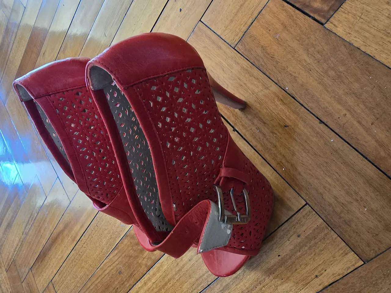 Sandalias rojas de taco alto con diseño calado y hebilla. Ideales para darle un toque audaz a tus looks de fiesta.