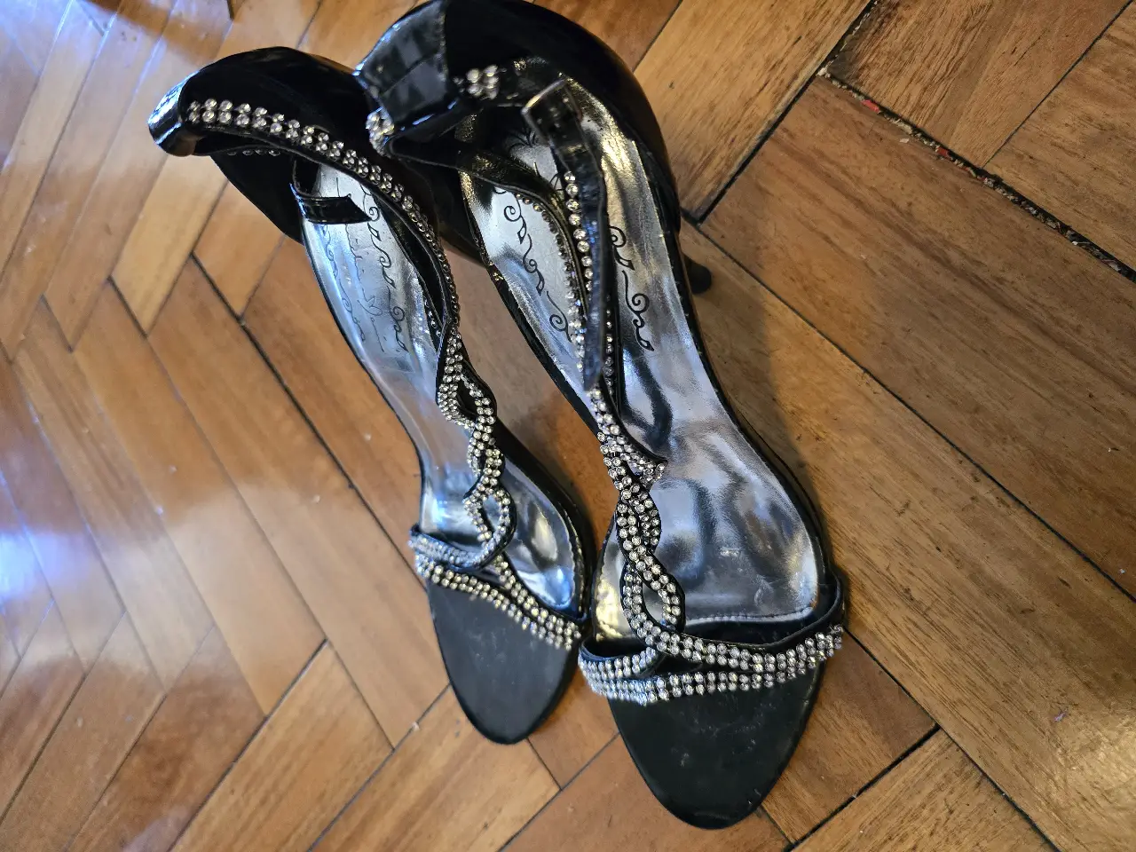 Sandalias de taco alto negras con detalles de strass. Ideales para eventos especiales y fiestas.