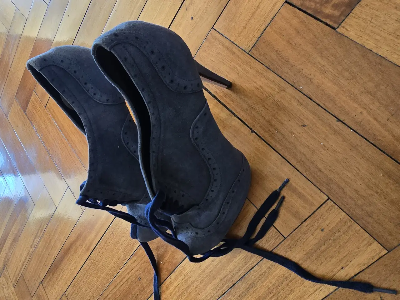 Zapatos de taco alto de gamuza azul con detalles de diseño y cordones. Ideales para eventos formales o salidas nocturnas.