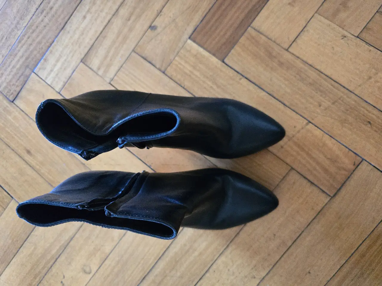 Botines de cuero negro con taco fino. Diseño elegante y versátil, ideales para complementar cualquier outfit.