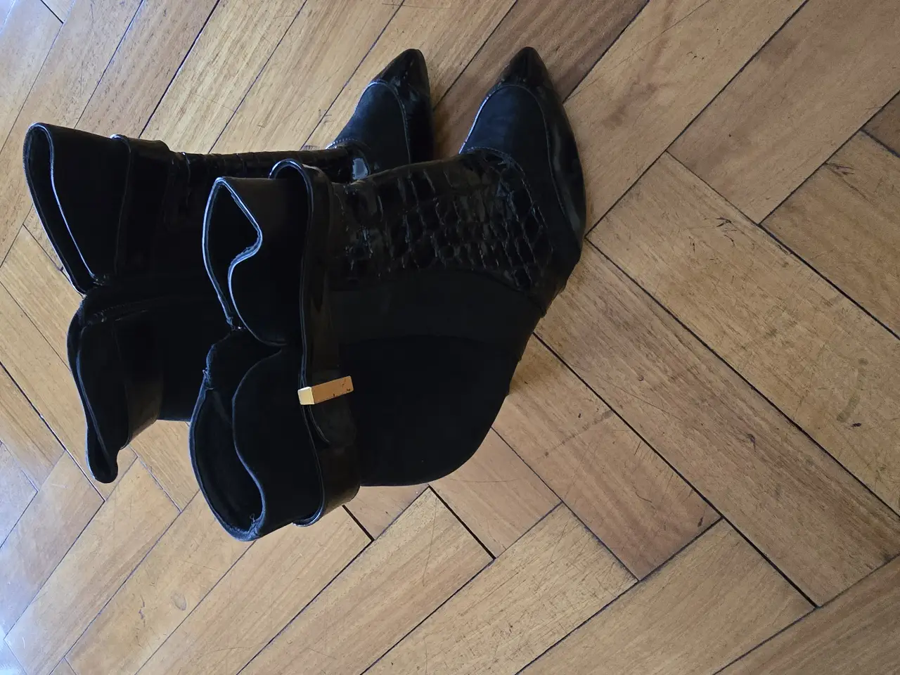 Botas de caña baja con detalles de cuero y gamuza. Diseño elegante con taco y cierre lateral. Ideales para un look sofisticado.