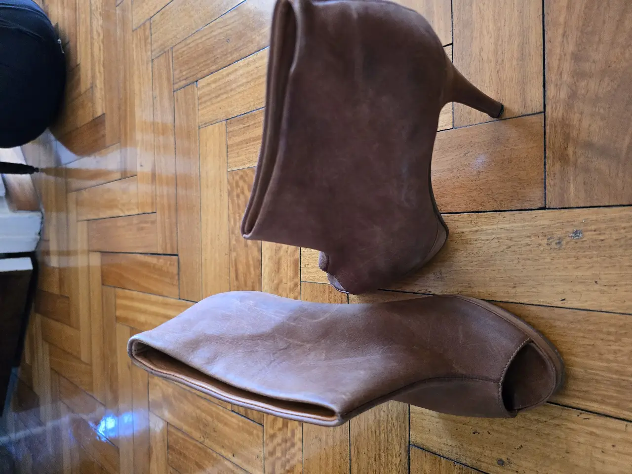 Botas de cuero marrón con taco alto y diseño abierto en la punta. Ideales para un look sofisticado y moderno.