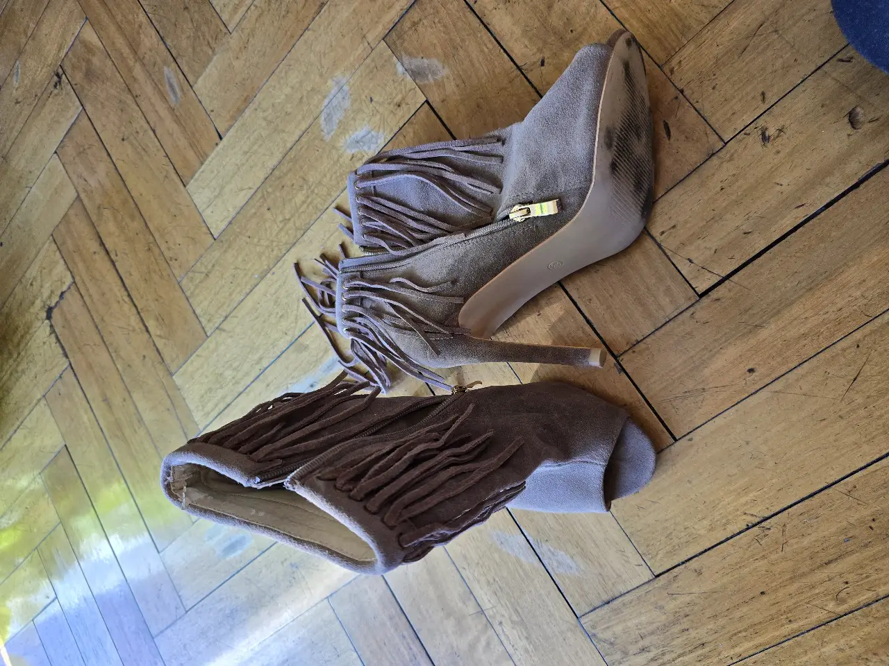 Botines de gamuza con flecos, taco fino y diseño peep toe. Ideales para un look boho chic.