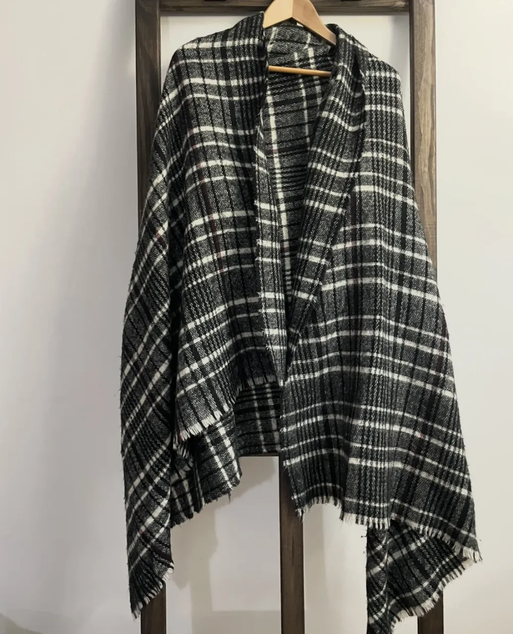 Poncho a cuadros en blanco y negro, ideal para el invierno. Perfecto para un look casual y abrigado.
