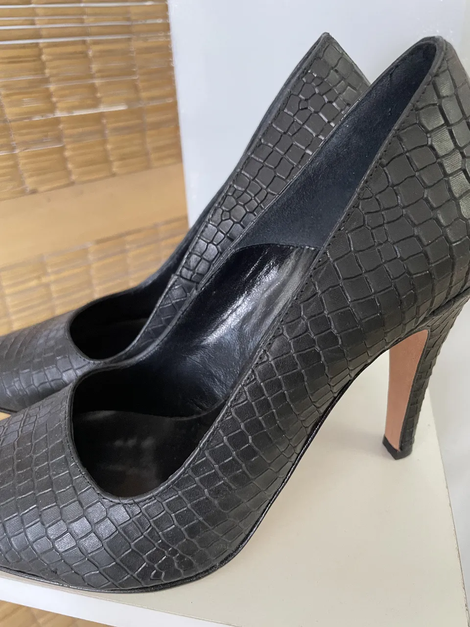 Elegantes zapatos de taco alto negros con diseño de reptil. Ideales para eventos formales o salidas nocturnas. Un clásico atemporal para cualquier guardarropa femenino.