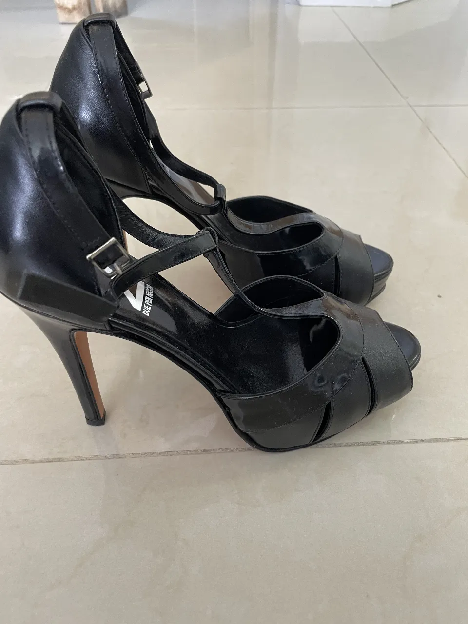 Sandalias de taco alto negras, con pulsera en el tobillo y diseño peep toe. Ideales para eventos formales o salidas nocturnas.