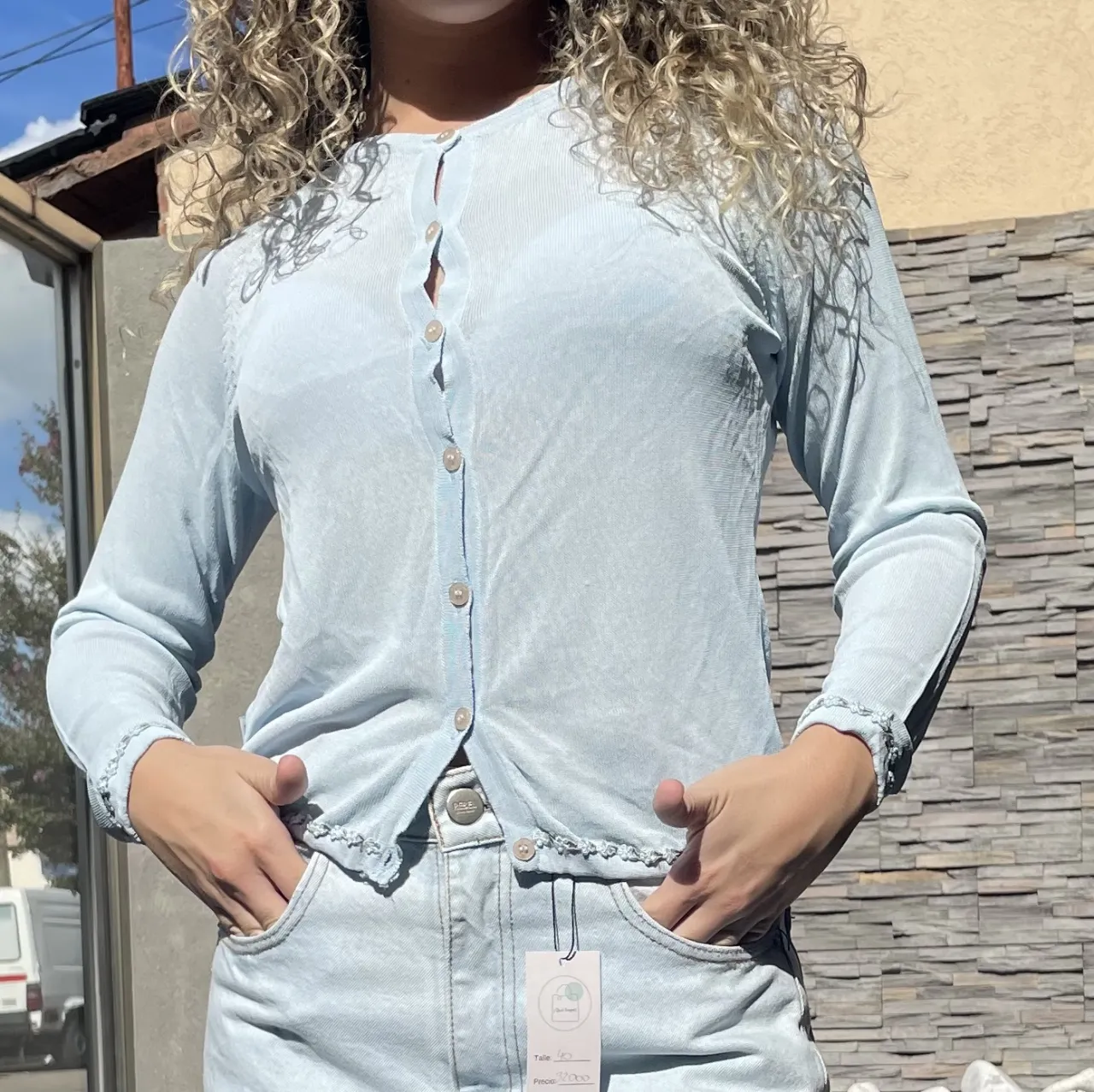 Cardigan celeste de punto fino con botones y detalles de bordado en los bordes. Ideal para un look casual y femenino.