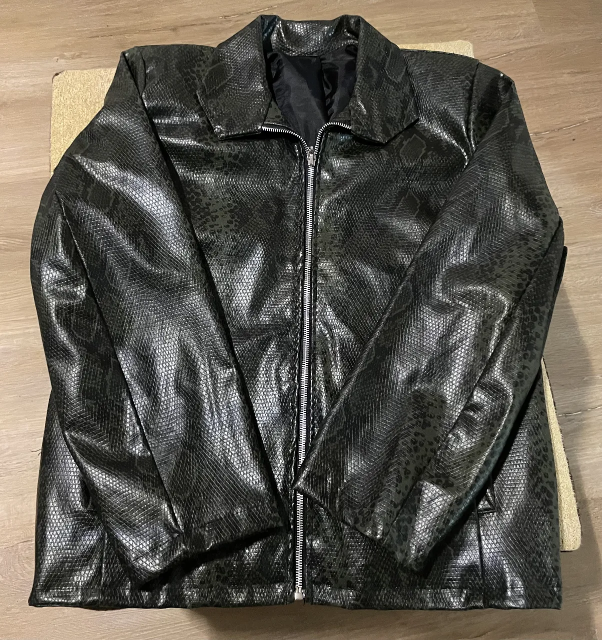 Campera biker de cuero sintético con estampado de serpiente. Ideal para un look audaz y moderno. Cierre frontal y cuello con solapas.