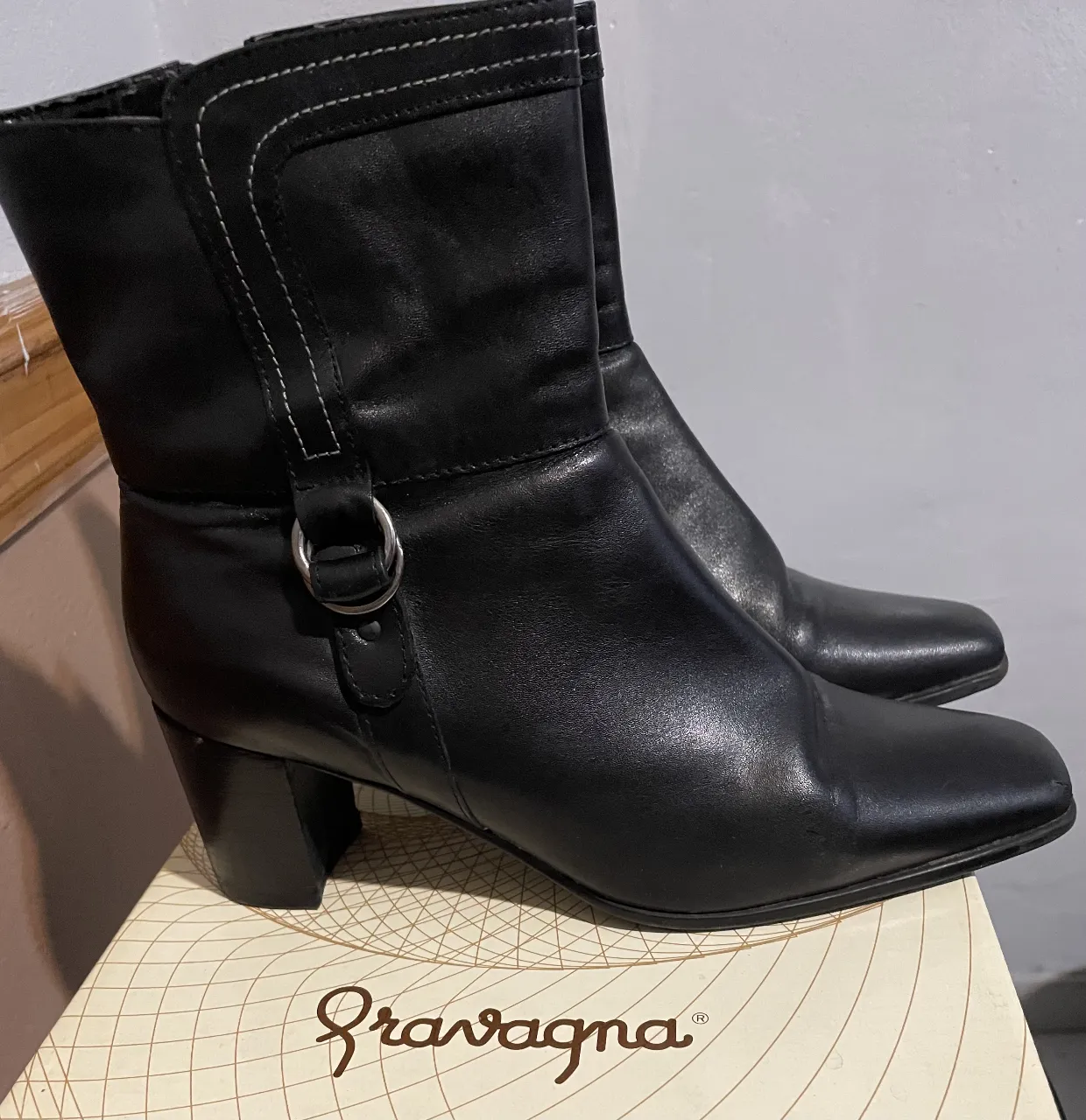Botines de cuero negro con taco cuadrado y detalle de hebilla. Ideales para un look elegante y versátil.