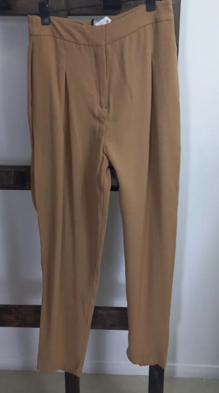 Pantalón sastrero de mujer, color marrón. Corte recto, con pinzas delanteras y bolsillos traseros. Ideal para un look elegante y sofisticado.