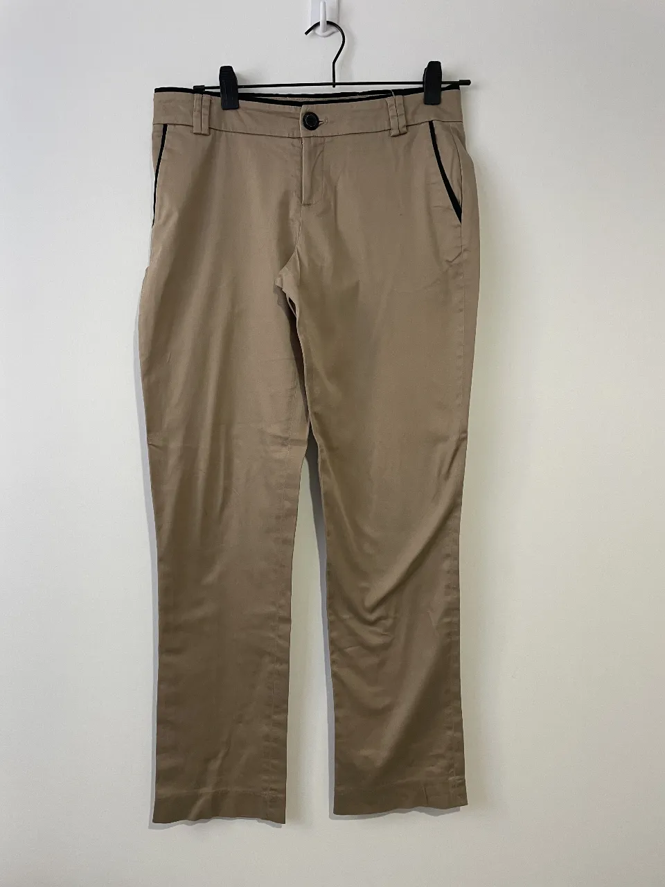 Pantalón sastrero de mujer en color khaki con detalles en negro. Corte recto y elegante, ideal para un look de trabajo o salida casual.