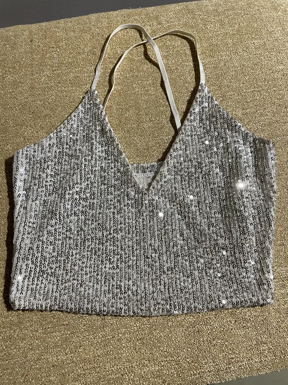 Top de fiesta para mujer, con lentejuelas plateadas brillantes. Diseño halter con tiras finas y espalda descubierta. Ideal para eventos y salidas nocturnas.