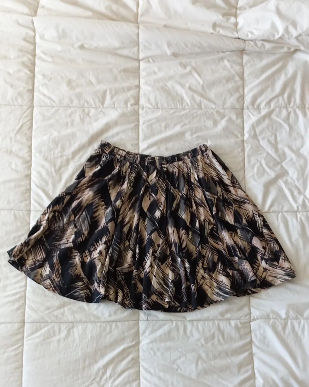 Pollera corta estampada con un diseño abstracto en tonos rosa y negro. Posee cintura elastizada para mayor comodidad. Ideal para un look casual y moderno.