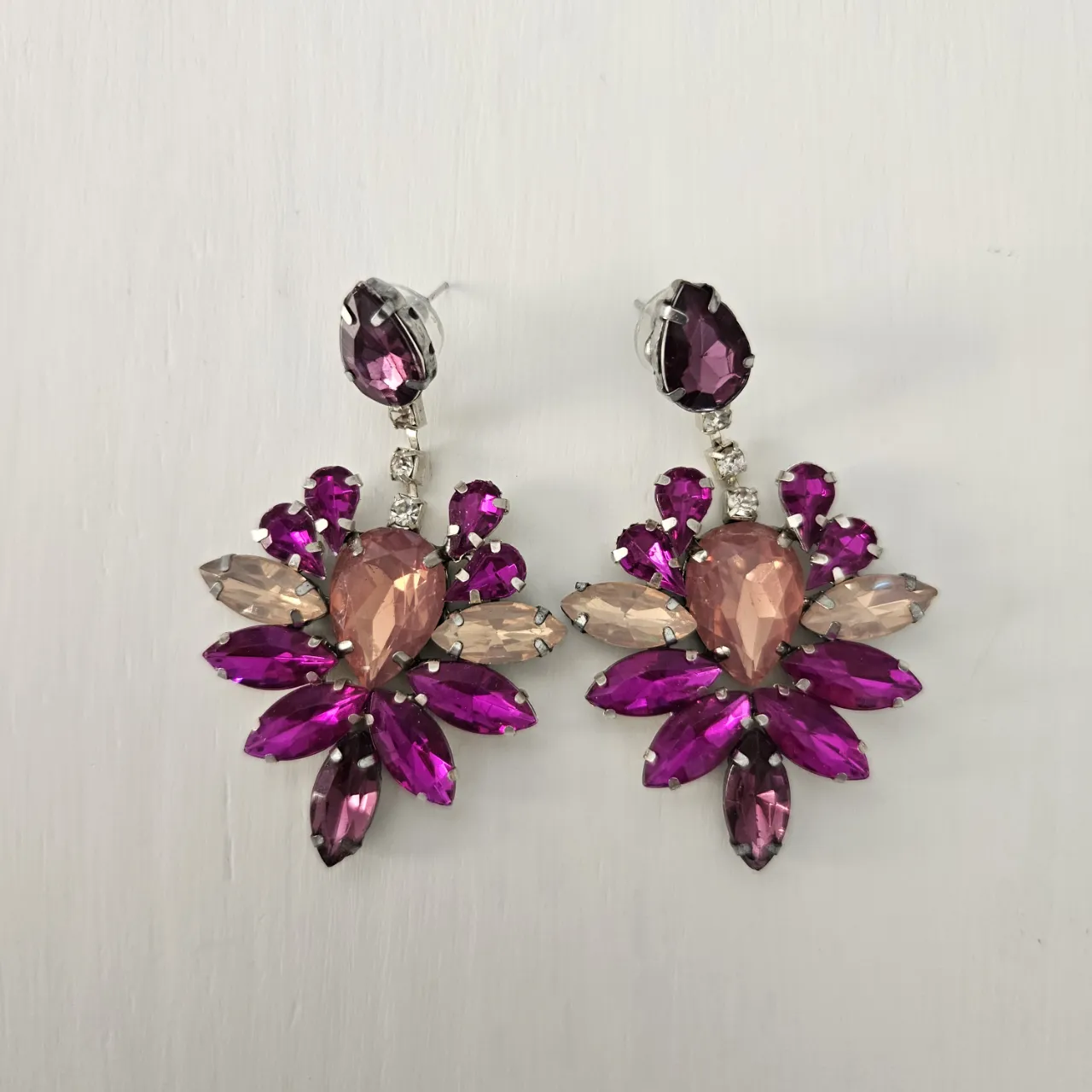 Aros colgantes súper llamativos con forma de flor, llenos de piedras de strass en tonos fucsia, rosa pálido y un toque de violeta. 

un solo uso
