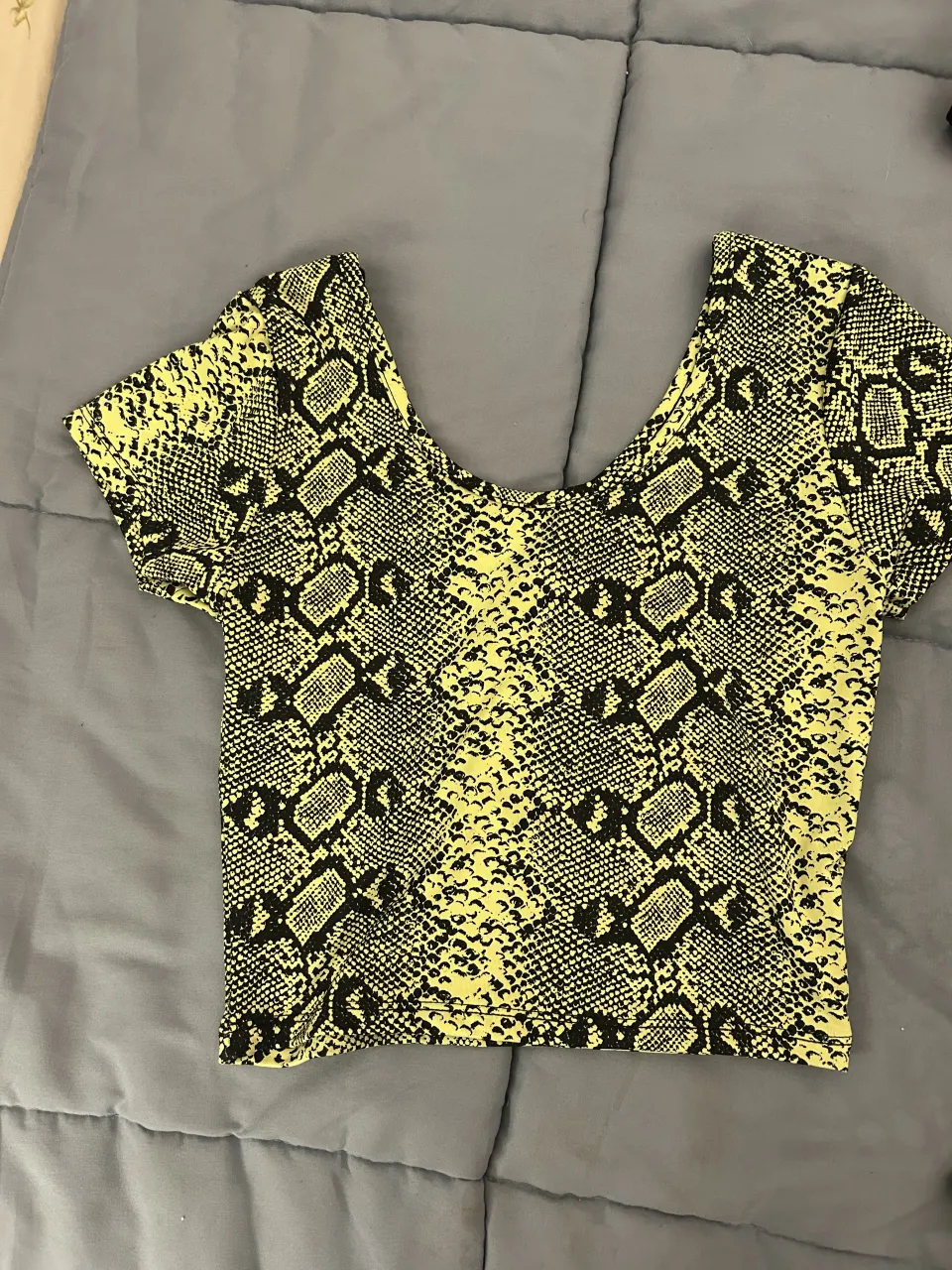 Remera estampada con motivo de serpiente en tonos amarillo y negro. Escote redondo y mangas cortas.