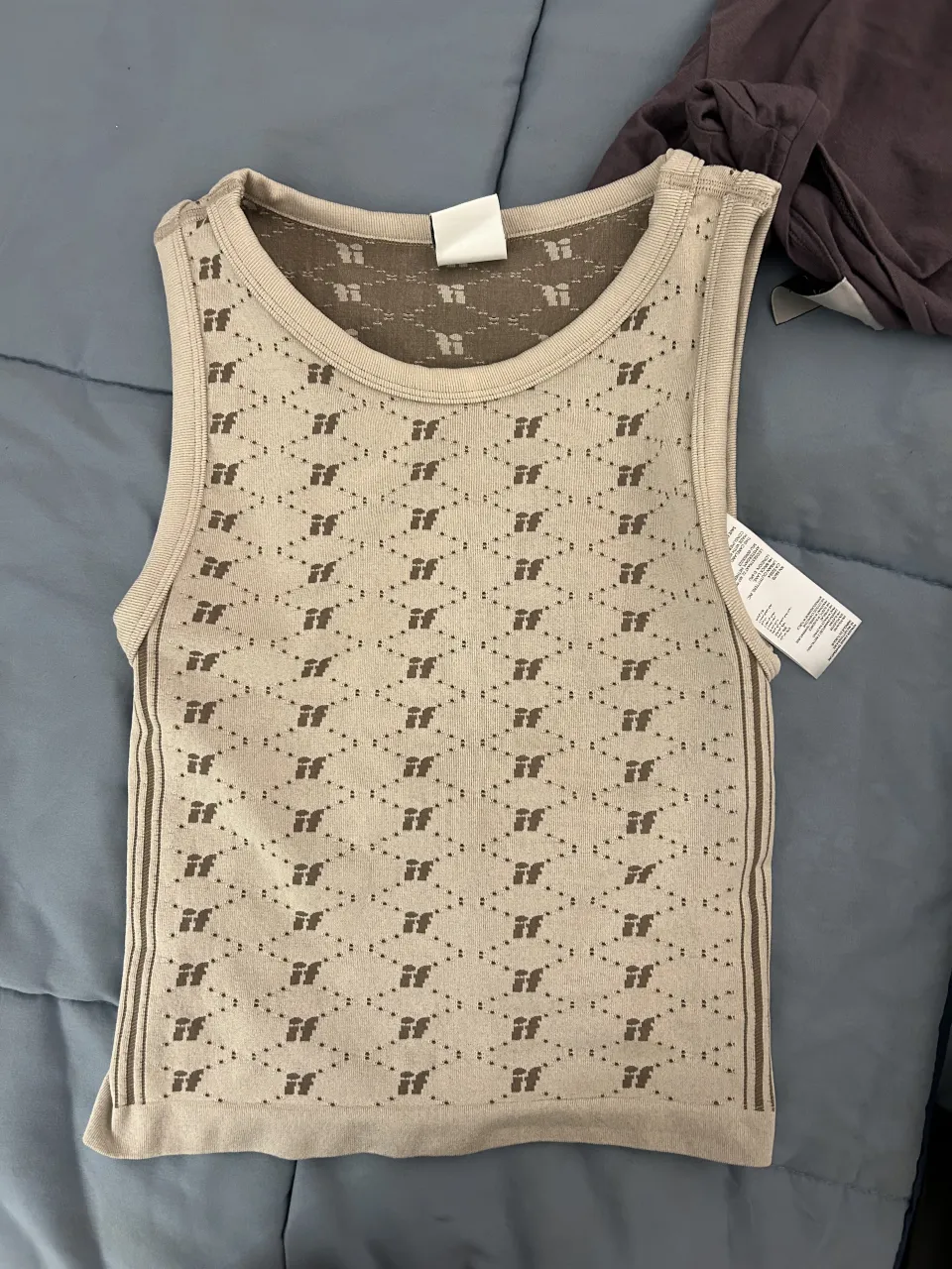 Musculosa de tejido color tiza con estampa geométrica en marrón. Posee tiras finas y espalda descubierta con lazo.