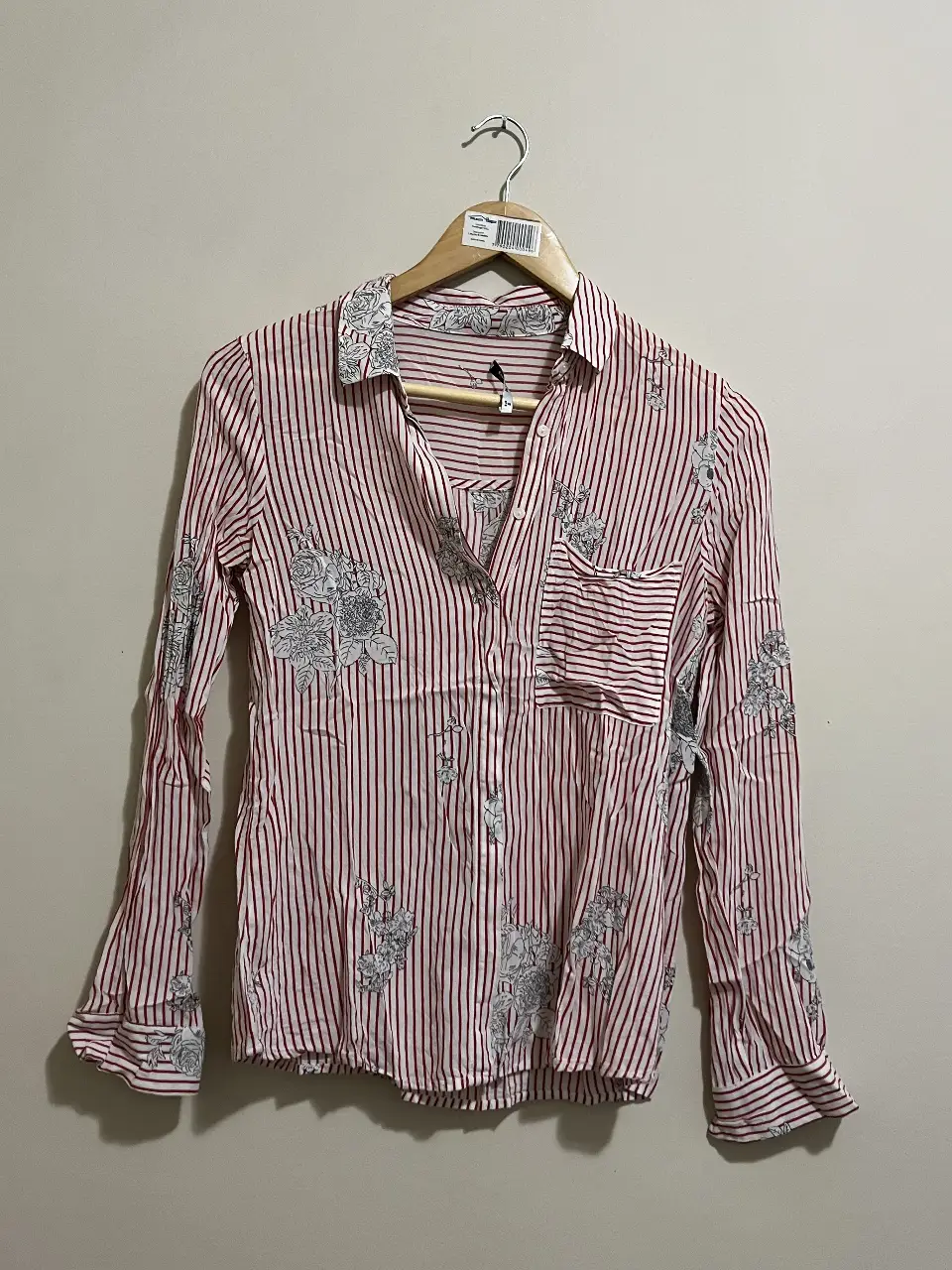 Camisa a rayas rojas y blancas con estampado floral en tonos grises. Ideal para un look casual y fresco.