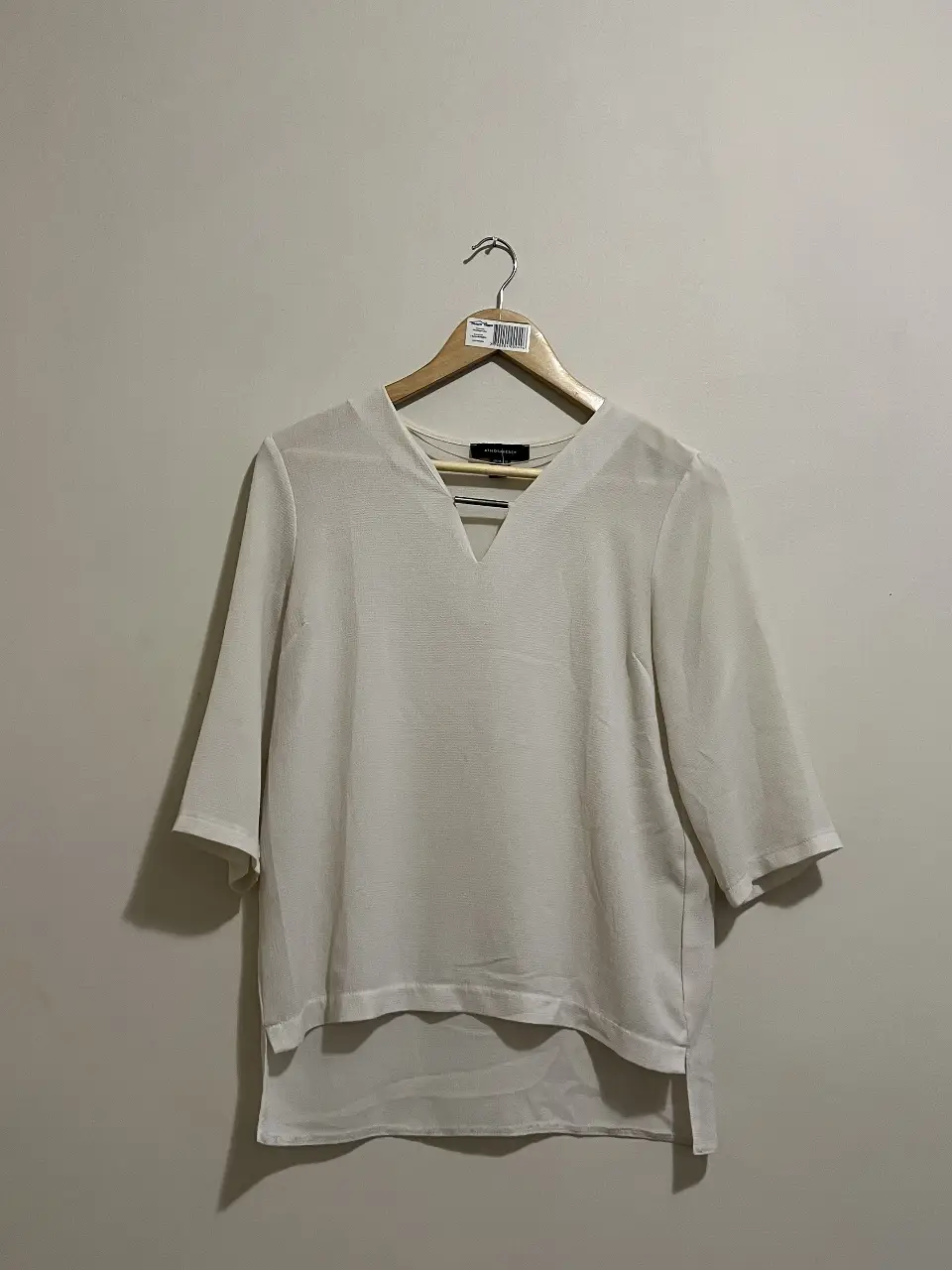Blusa blanca con escote en V y mangas 3/4. Ideal para un look casual y elegante.