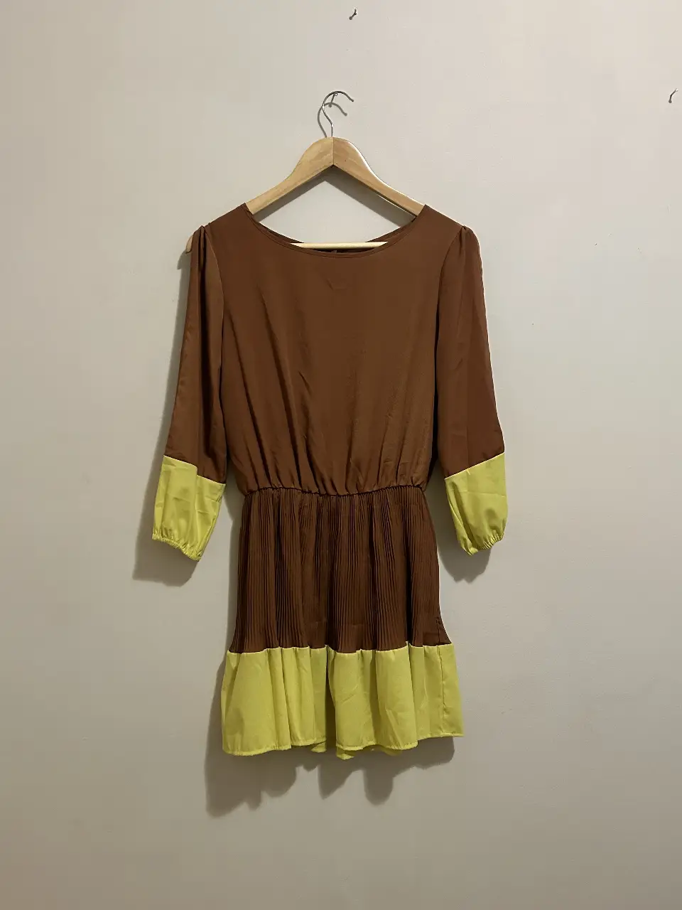 Vestido mini de mujer, con mangas 3/4 y cintura entallada. La parte superior es marrón y la inferior, junto con los puños, es amarilla. Ideal para un look casual y moderno.
