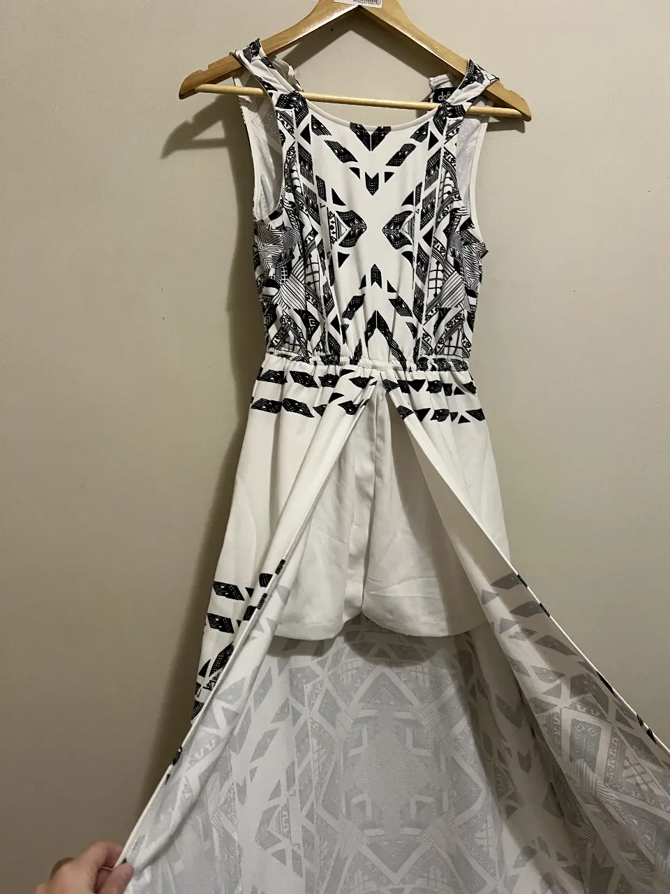 Vestido largo blanco con estampado geométrico en negro, con tajo y short. Diseño con escote en V y corte en la cintura. Ideal para un look fresco y moderno.