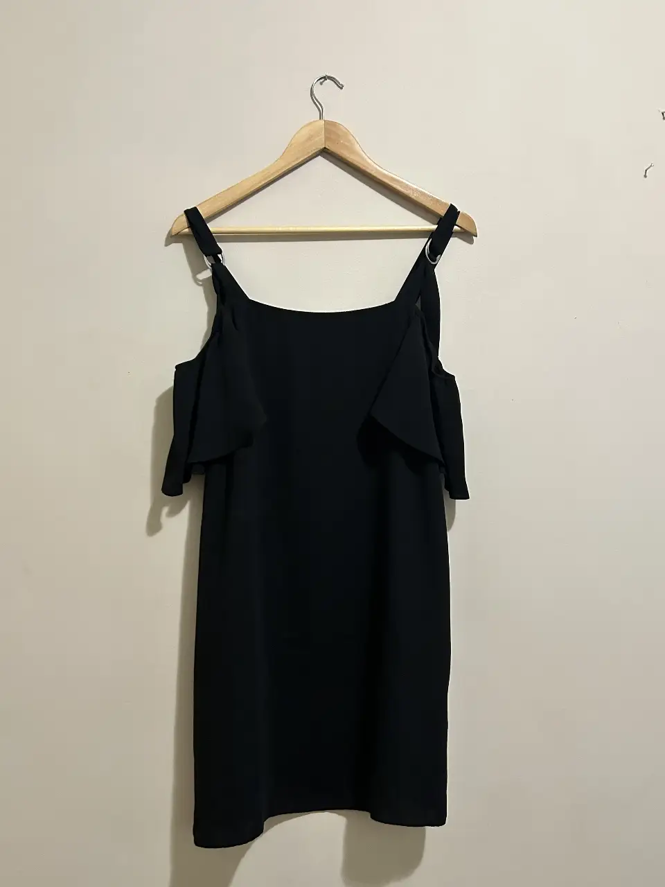 Vestido negro mini con breteles anchos y detalles de volados en los hombros. Ideal para una salida casual o una fiesta.