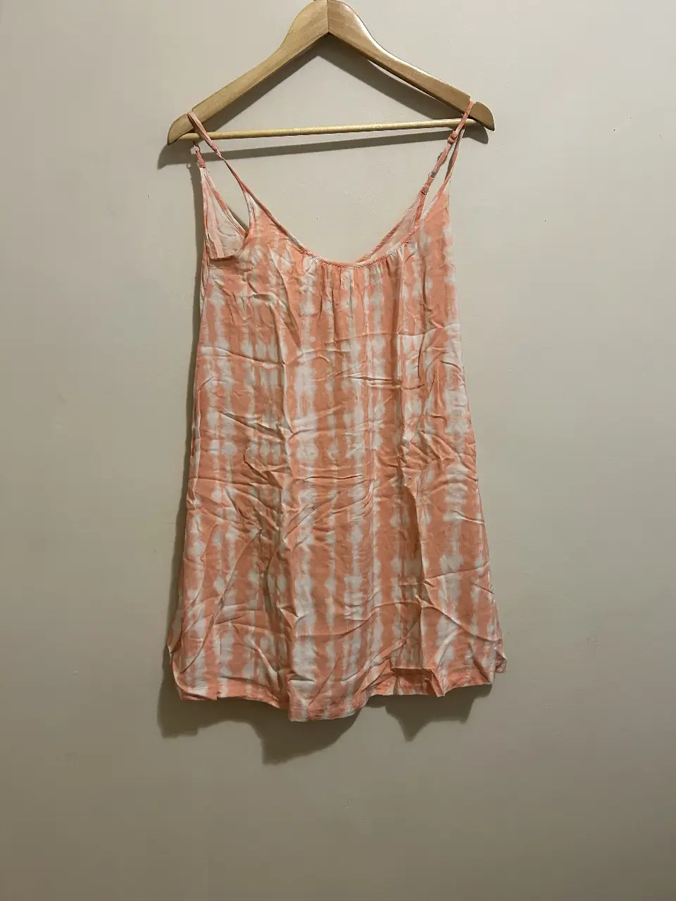 Vestido mini con tirantes finos y estampado tie-dye en tonos rosa y blanco. Ideal para el verano, este vestido es perfecto para un look casual y fresco.