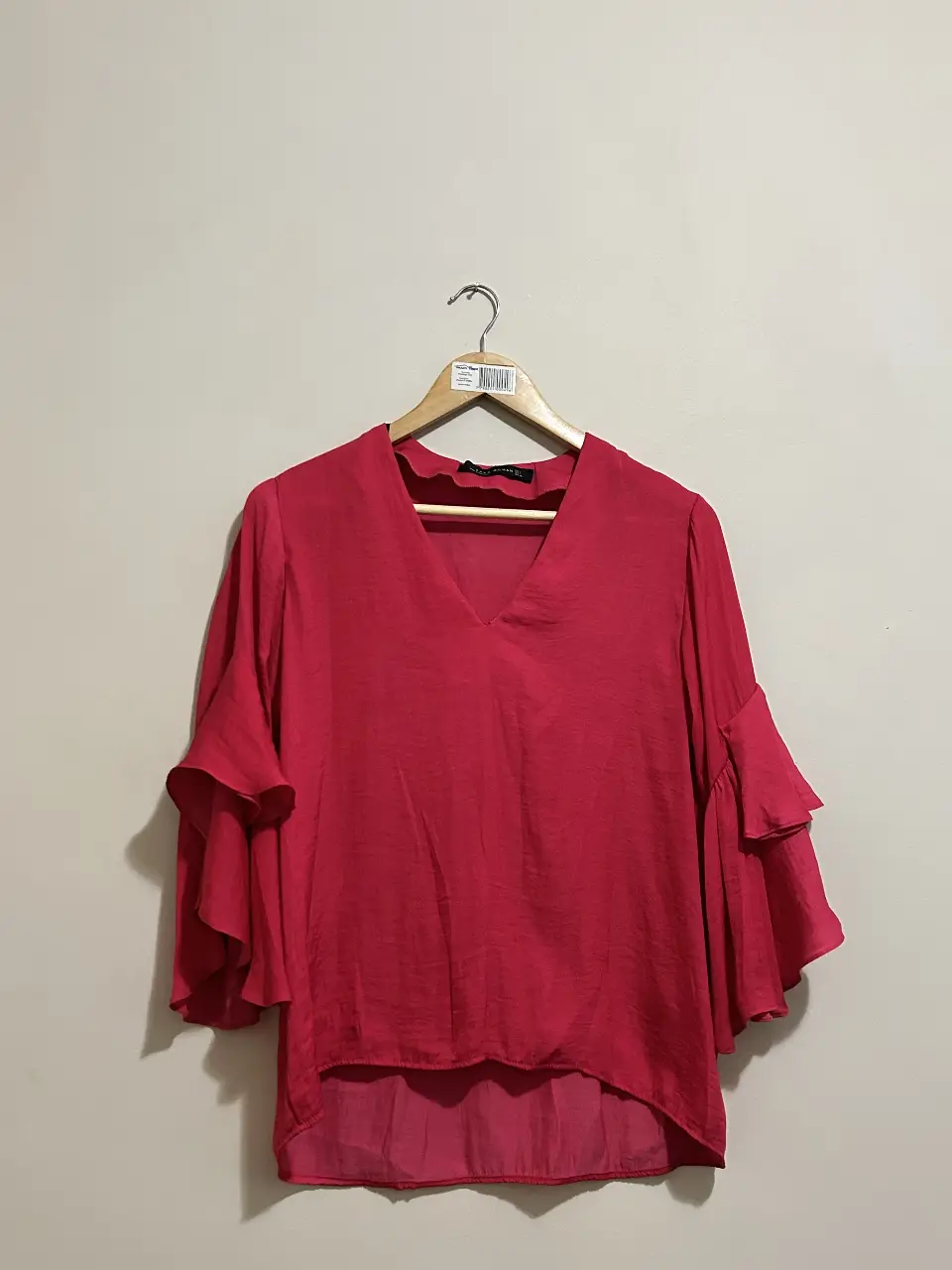 Blusa roja con mangas 3/4 y volados. Ideal para un look elegante y femenino.