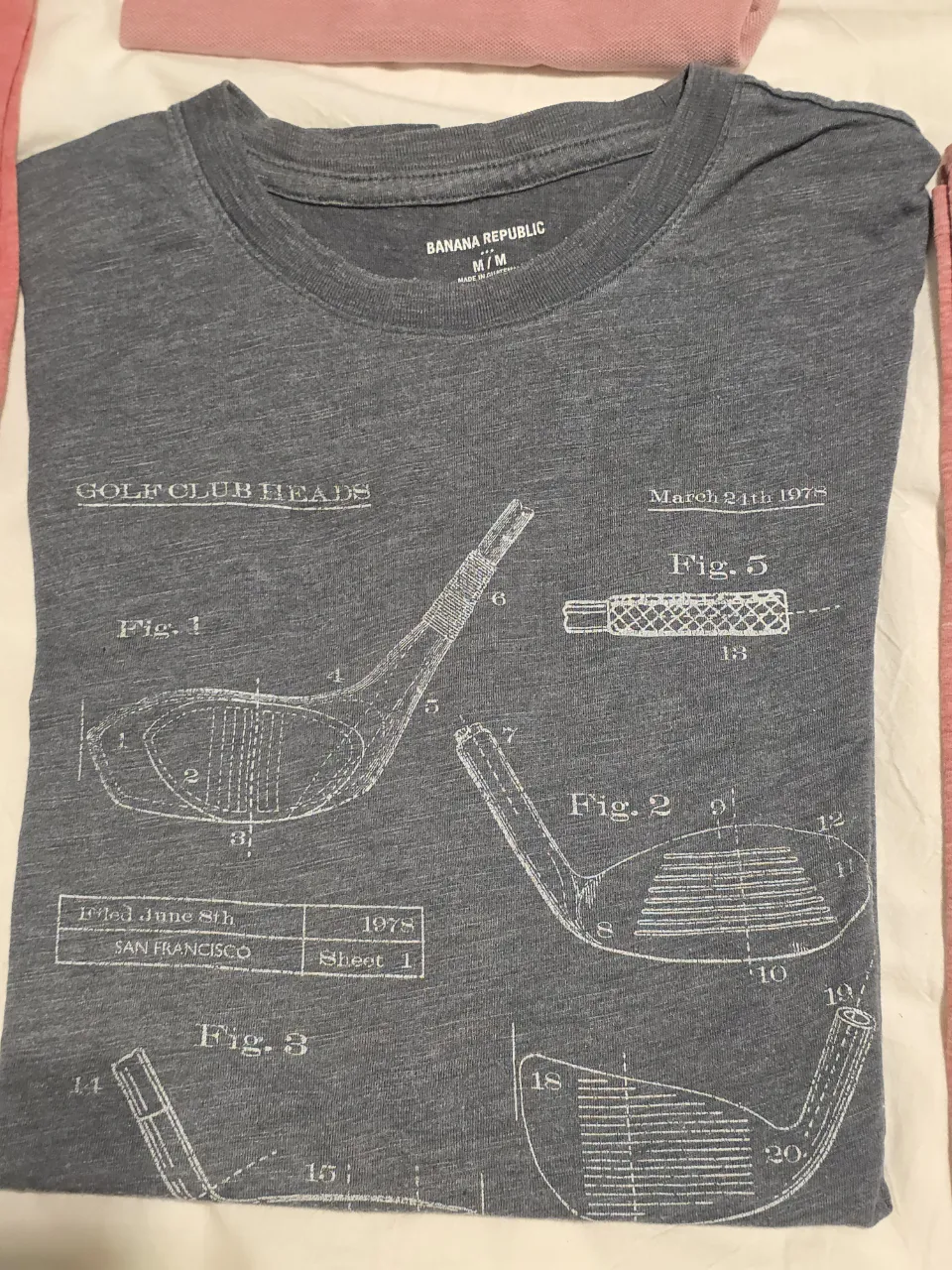 Remera de hombre gris con estampado de diseño de palos de golf. Marca Banana Republic, talle M/M.