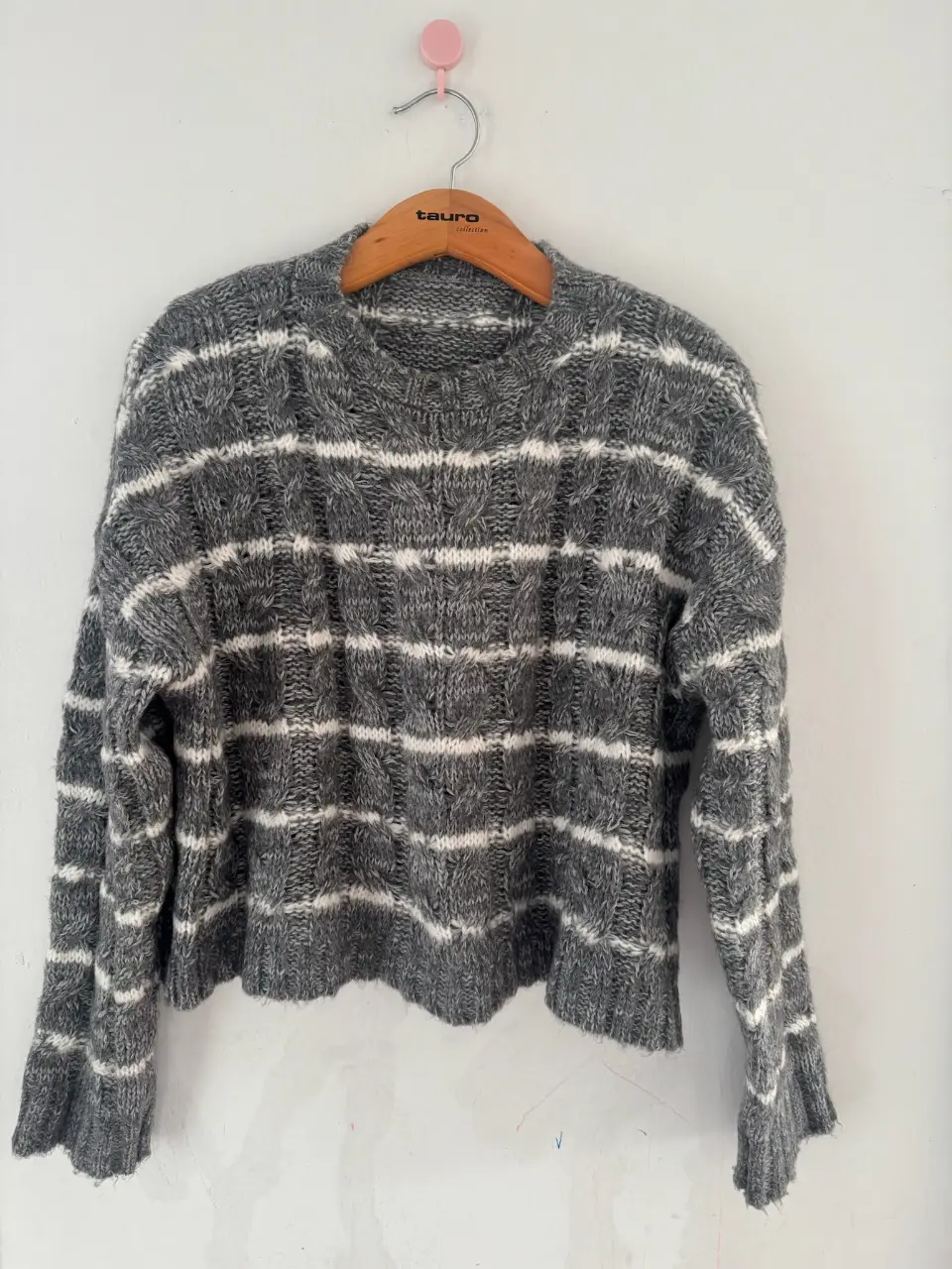 Sweater de lana gris con rayas blancas. Ideal para un look casual y abrigado.