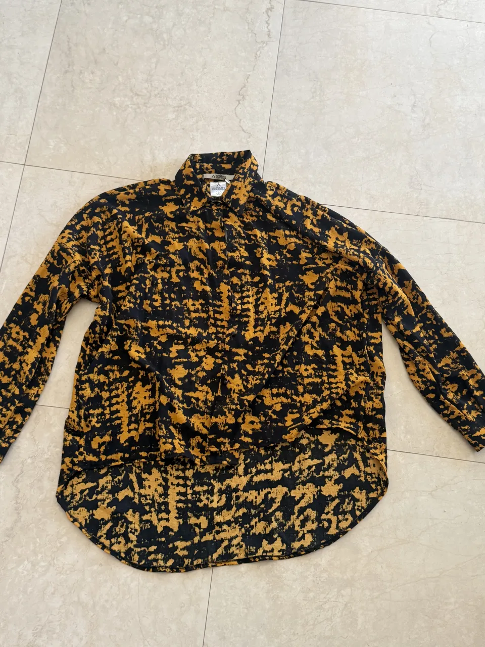 Camisa estampada con cuello y mangas largas.