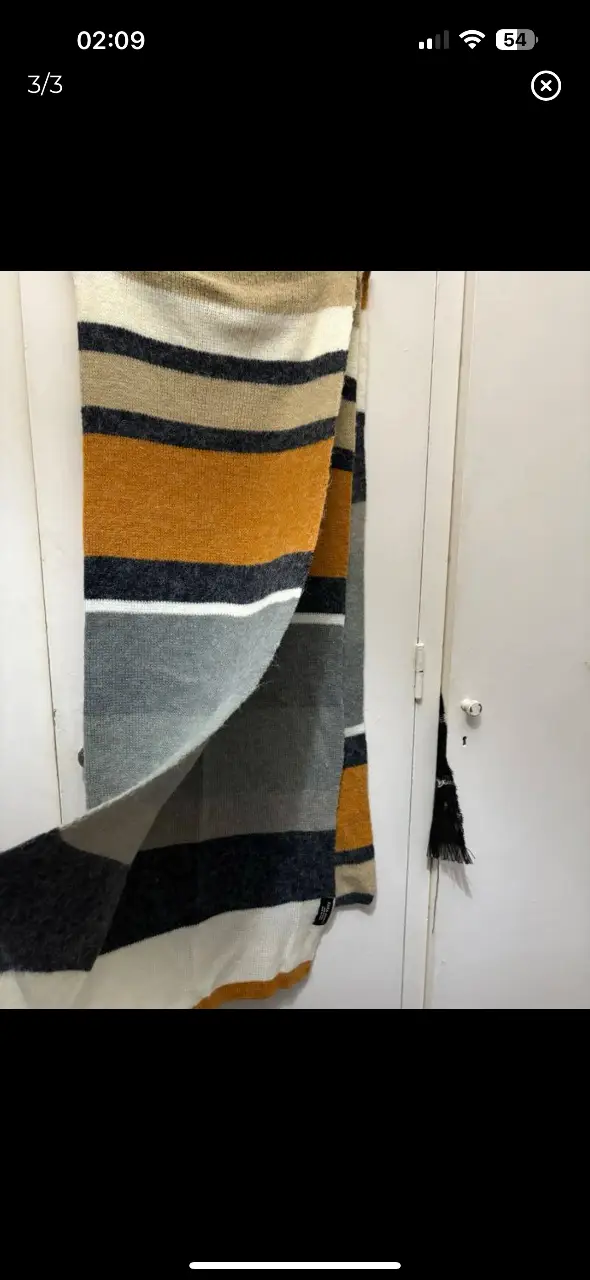 Bufanda a rayas de la marca Zara, con diseño en tonos grises, amarillos y blancos. Ideal para el invierno.
