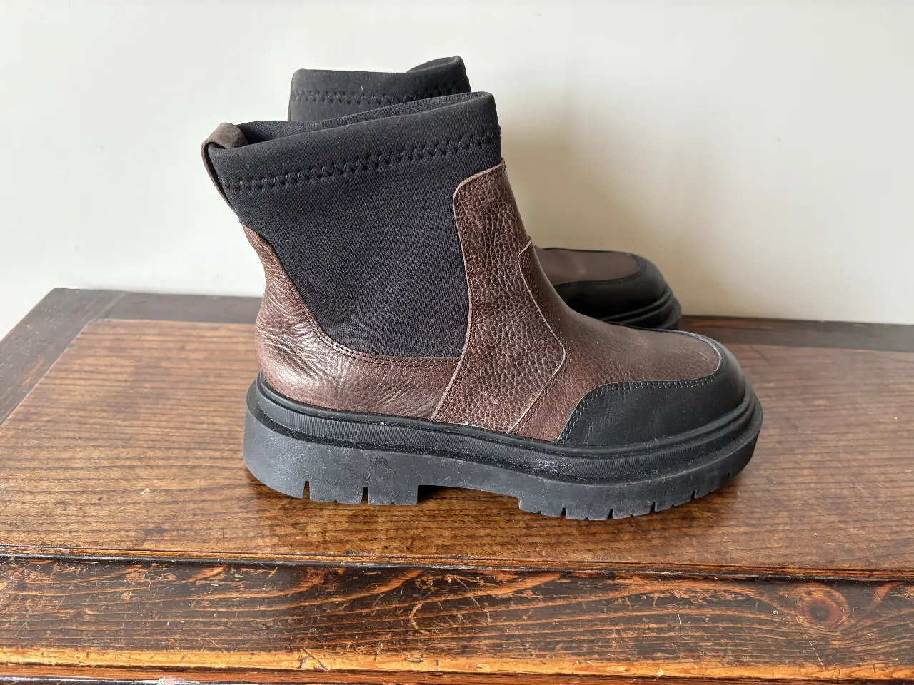 Botines de cuero marrón y negro con suela gruesa. Ideales para un look urbano y moderno.