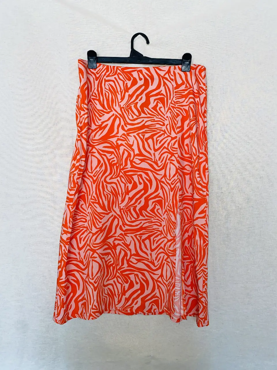 Pollera larga con estampado de cebra en tonos naranja y blanco. Tiene un tajo lateral que le da un toque moderno y canchero. Ideal para un look de verano. talle 40.