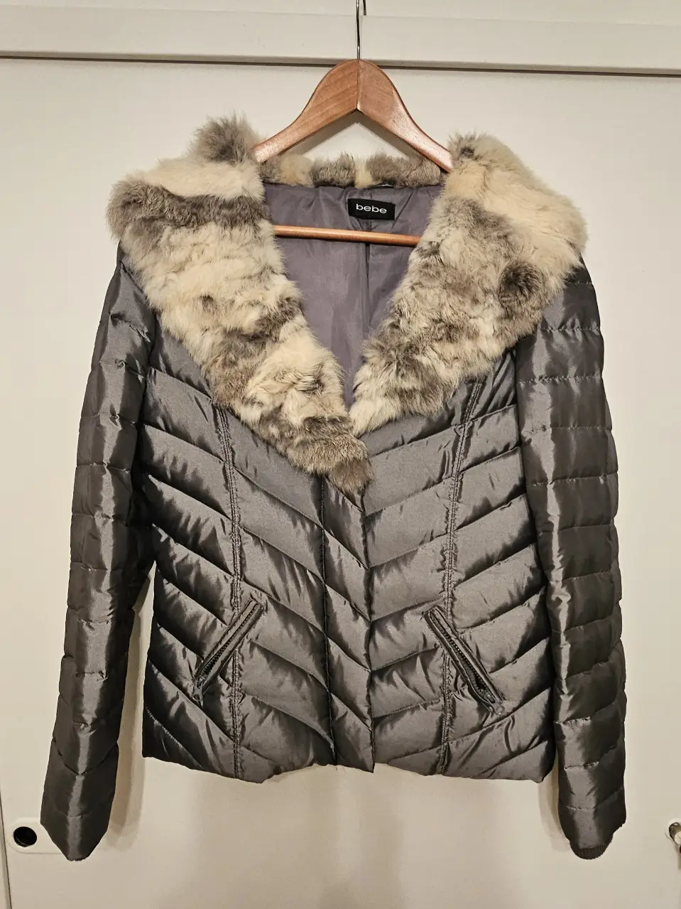 Campera de pluma gris de la marca Bebe, con cuello de piel y cierre. Ideal para el invierno.