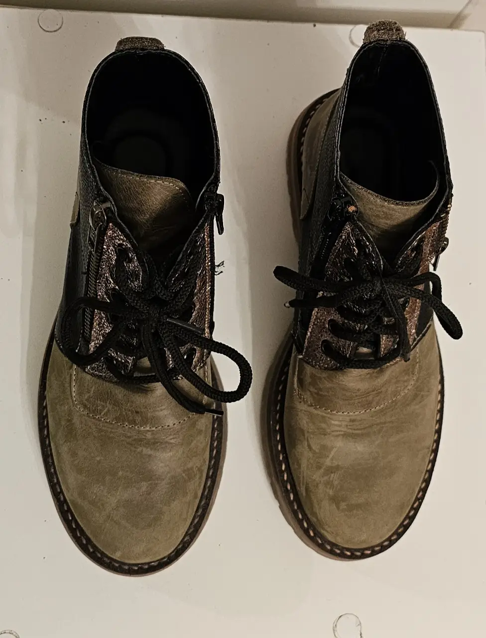 Botines de cuero con detalles en color bronce y cierre lateral. Ideales para un look casual y canchero.