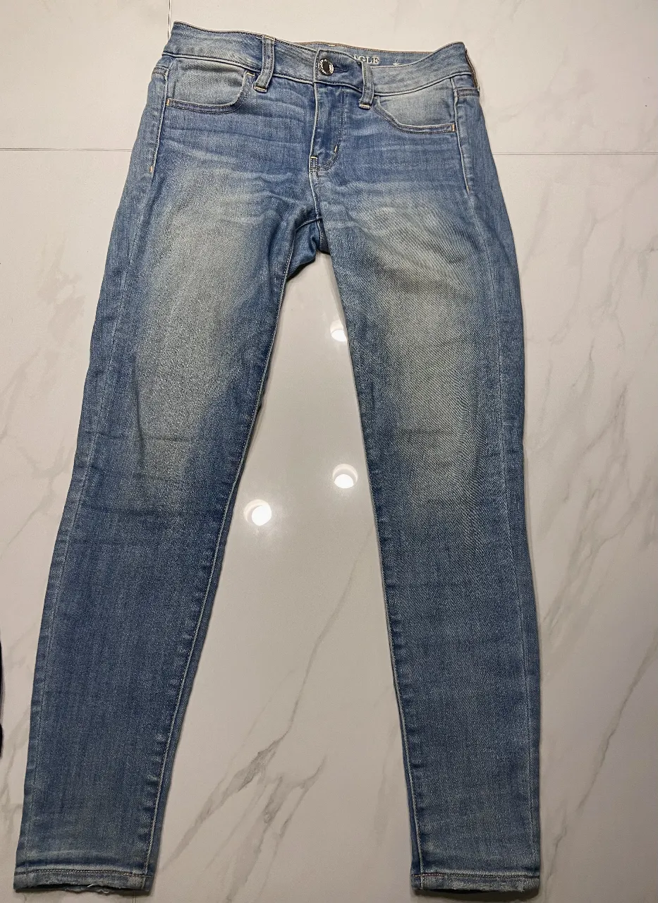 Jeans de mujer American Eagle, tiro bajo, color azul gastado, corte skinny. Ideal para un look casual y moderno.