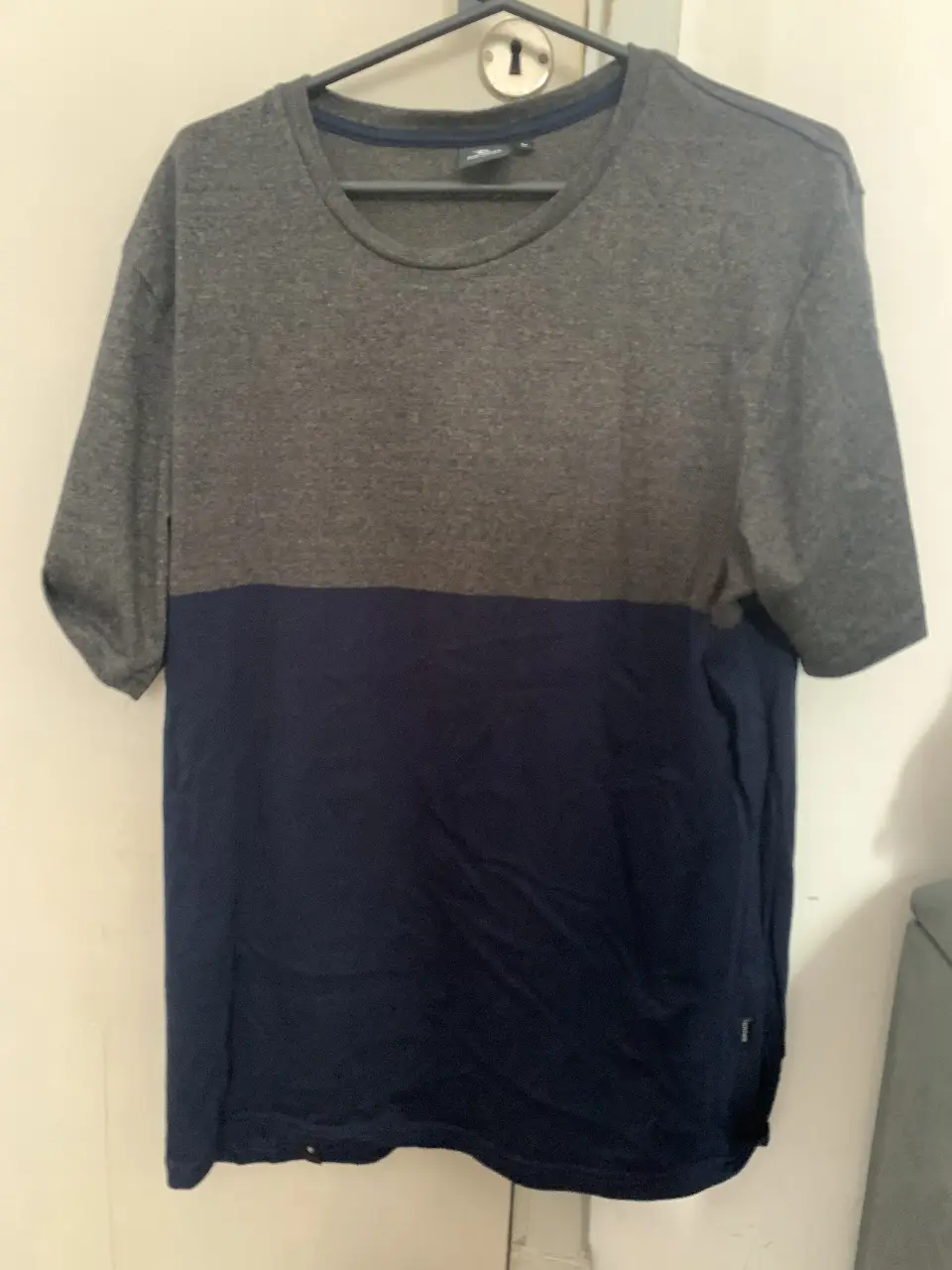 Remera manga corta para hombre, de color gris en la parte superior y azul en la inferior. Ideal para un look casual y cómodo.