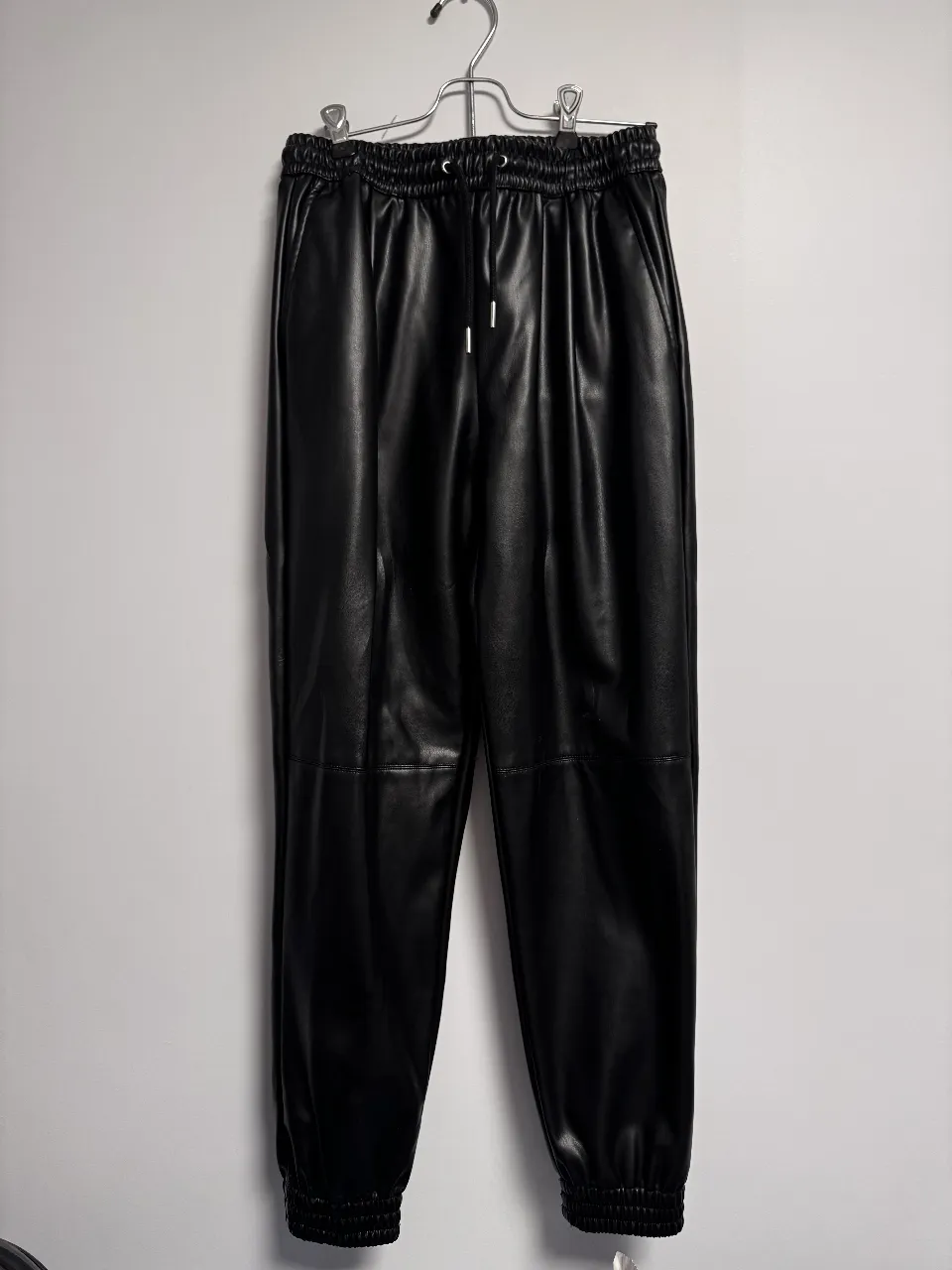 Pantalón de cuero sintético negro, con cintura elastizada y cordón. Talle XS de Zara. Ideal para un look moderno y cómodo.
