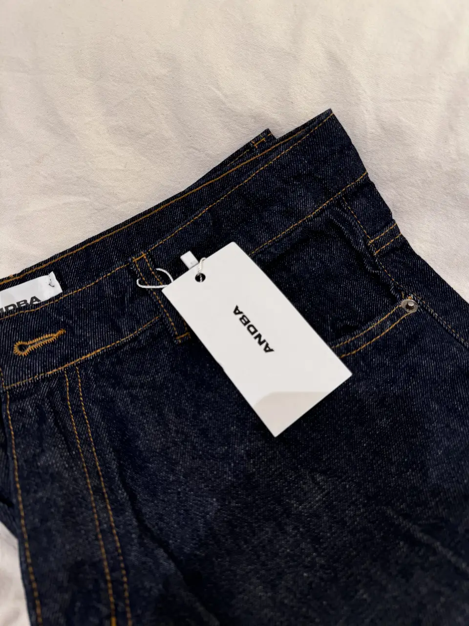 Jeans rectos de denim azul oscuro, con etiqueta. Marca ANDBA. Un clásico atemporal para cualquier guardarropa.
