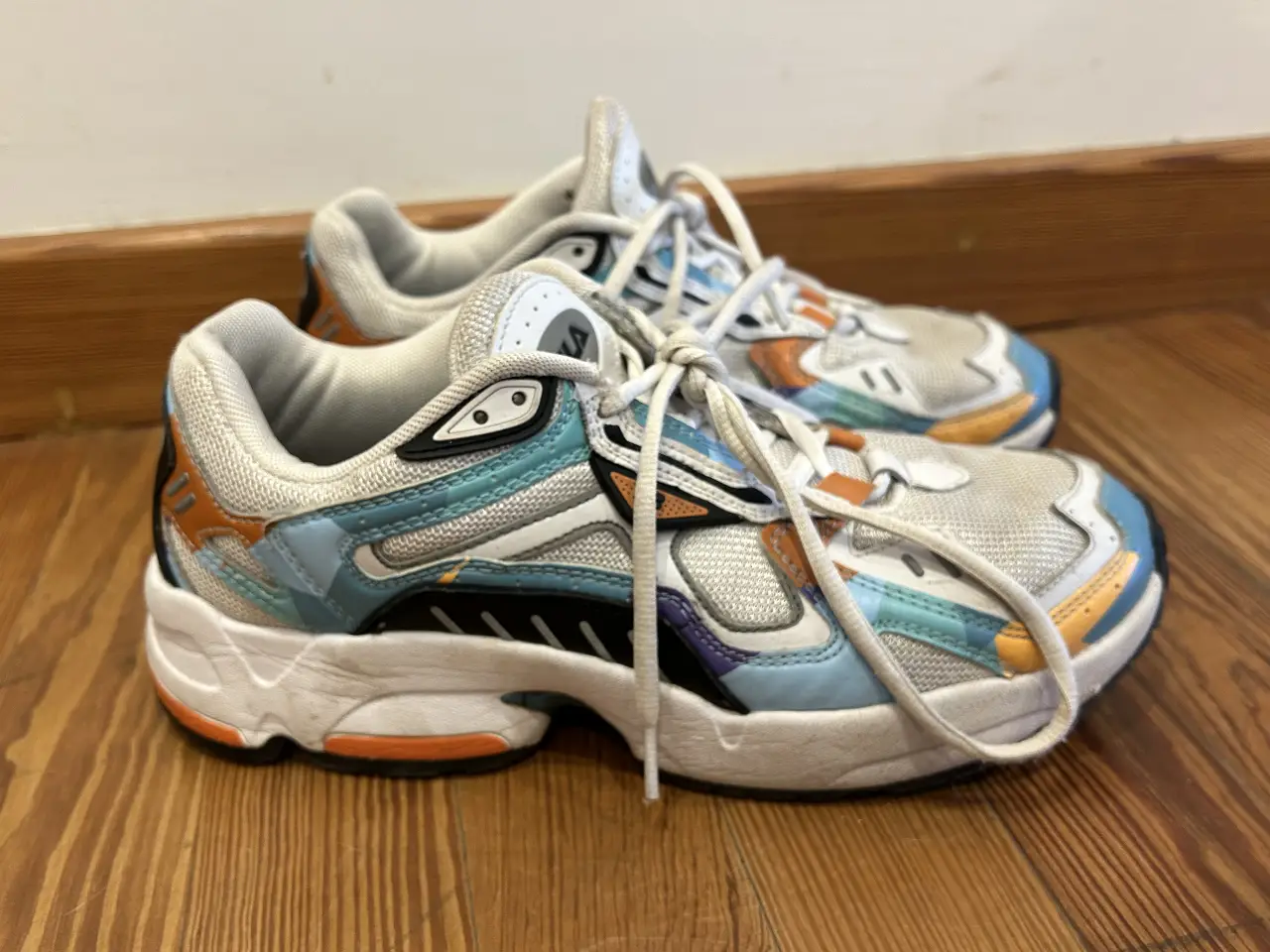 Zapatillas Fila retro, con detalles en azul, naranja y blanco. Ideales para un look deportivo y casual.