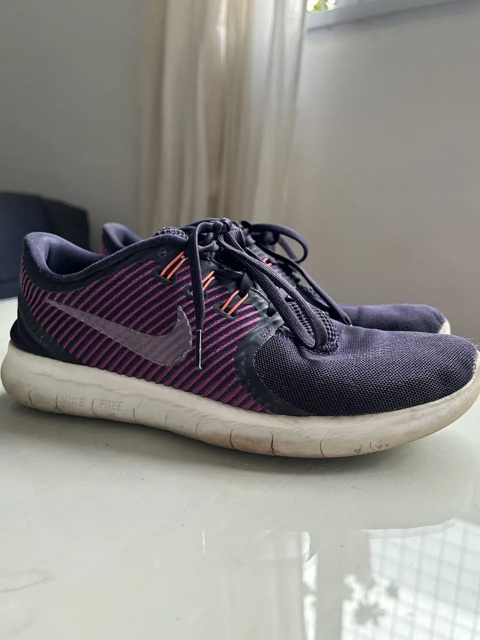 Zapatillas Nike Free, color violeta y rosa, ideales para running y entrenamiento. Diseño moderno y cómodo.