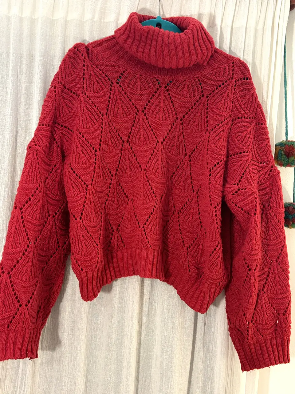Sweater de mujer rojo con cuello alto y diseño calado. Ideal para un look casual y abrigado en invierno.