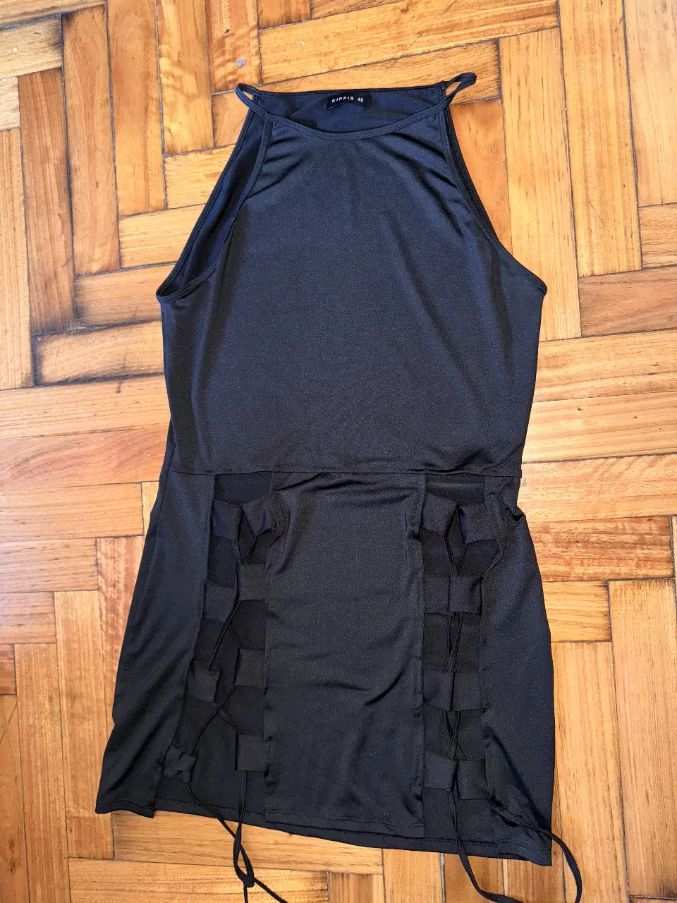 Vestido negro con diseño halter y detalles calados en los laterales. 