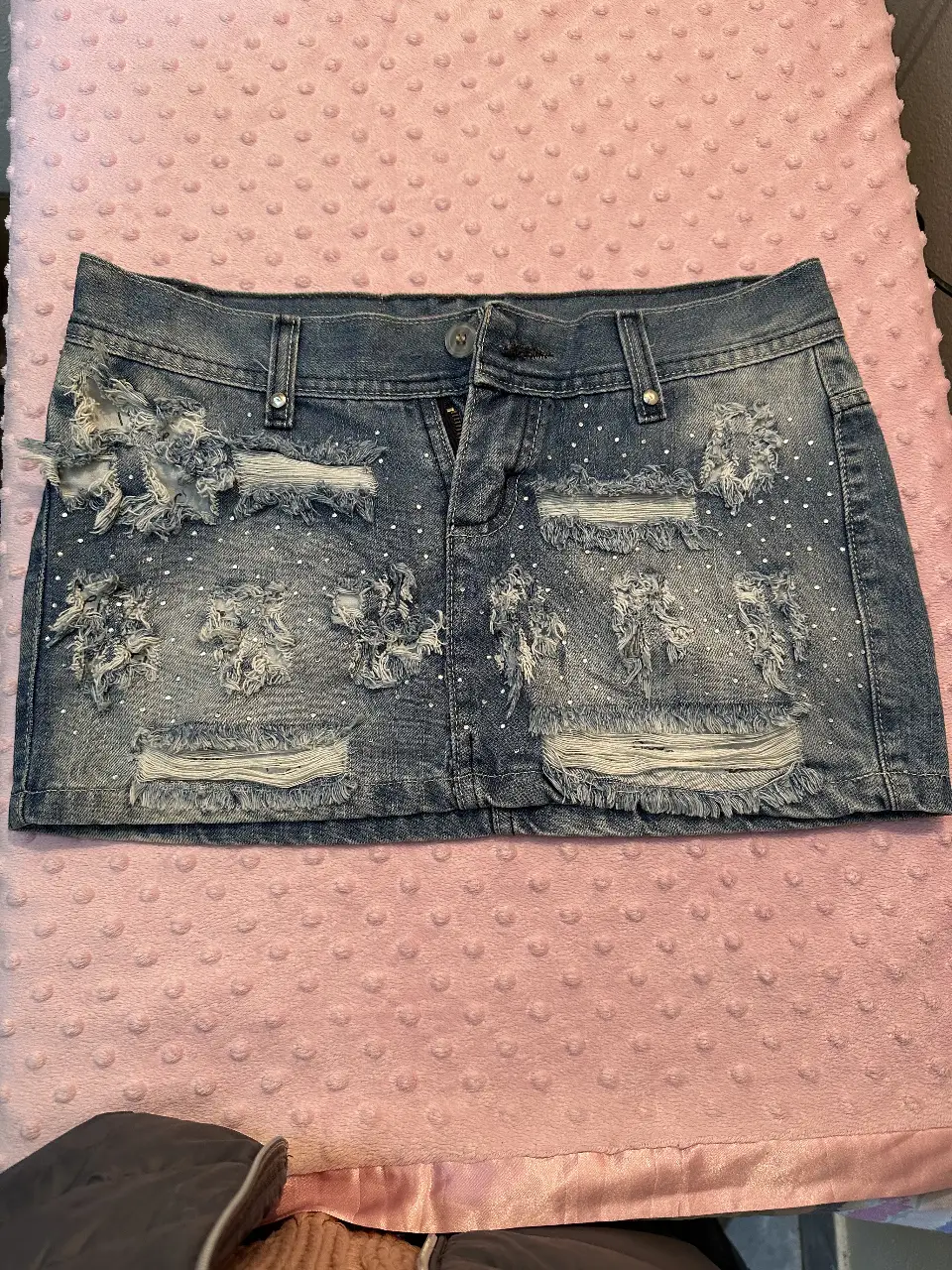 Minifalda de jean con detalles rotos y strass. Ideal para un look Y2K.