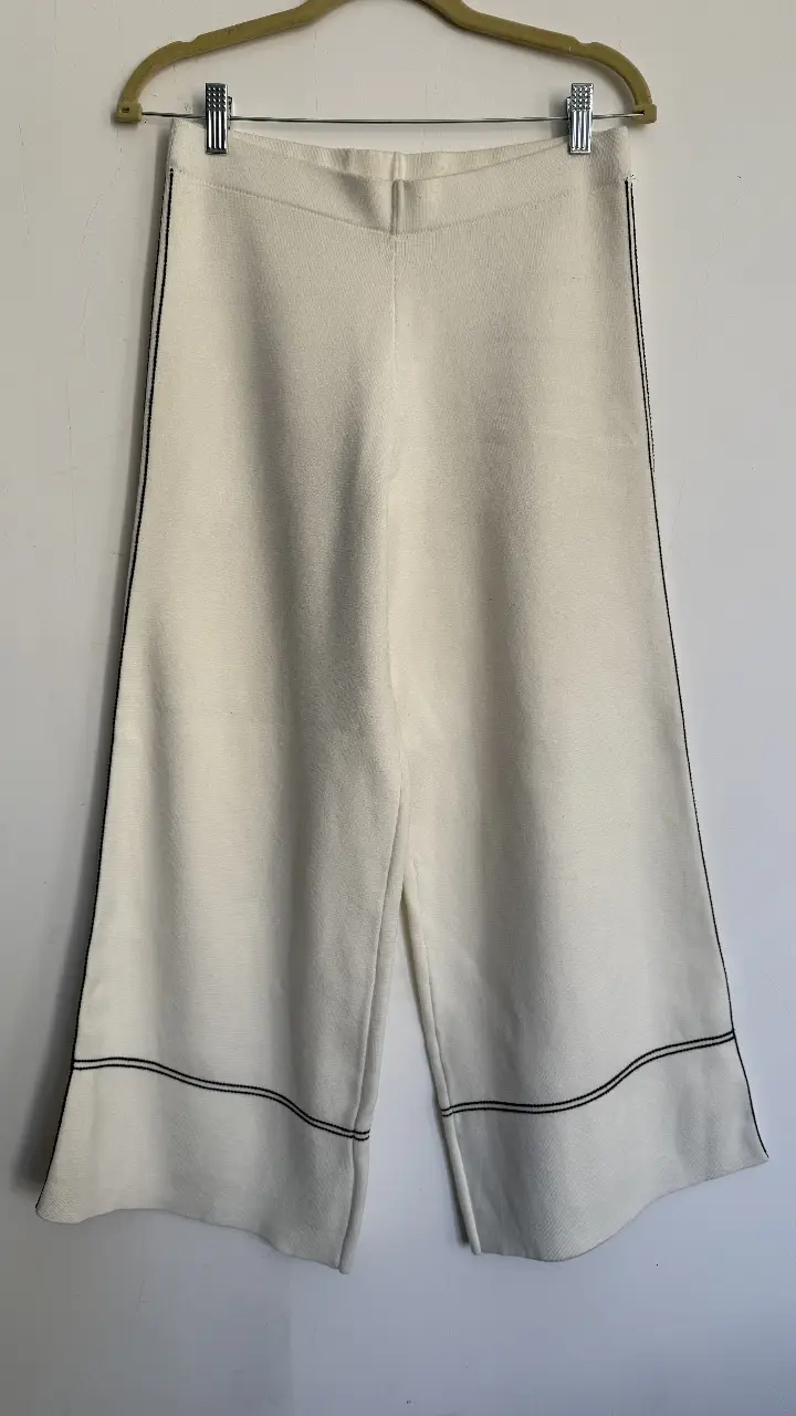 Pantalón sastrero blanco con detalles en negro. Corte amplio y elegante, ideal para un look sofisticado y cómodo.
